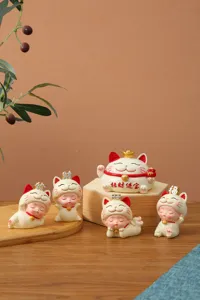 Close-up of five cute Maneki-neko lucky cat figurines used as car dashboard decor