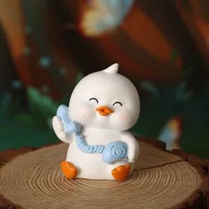 Close-up detail of a cute white duck figurine holding a blue vintage telephone on a wood stump