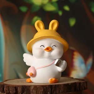Detailed close-up of a cute white duck figurine wearing a yellow bunny ear hat ornament
