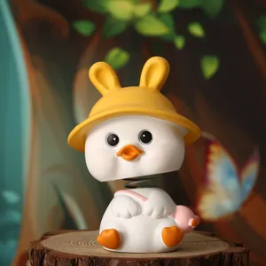 Close-up of cute shaking head duck figurine with yellow bunny ears hat