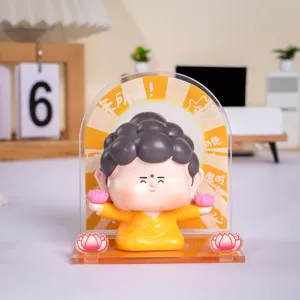 Schattig mini Boeddhabeeldje op bureau met creatieve achtergrond van acryl en lotus