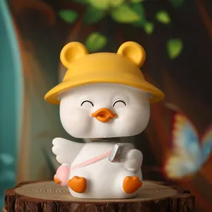 Detailed macro view of a cute white duck figurine wearing a yellow hat and pink bag