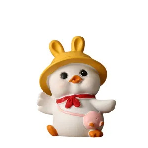Cute white duck ornament wearing a rabbit ear hat and red scarf for desktop decor