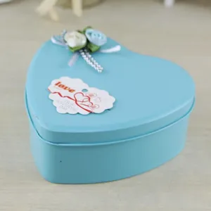 Dettaglio di una scatola regalo in metallo azzurro a forma di cuore con rose in