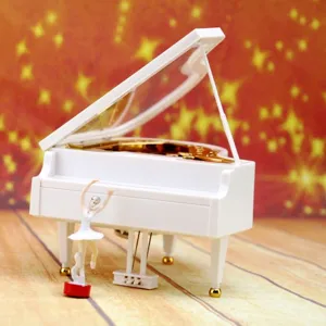 Detail of a white piano music box with a rotating ballerina figurine on a wooden floor