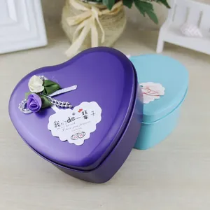 Vista dettagliata di due scatole regalo a forma di cuore in latta con rose di sapone.