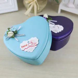 Dettaglio di scatola di latta a cuore con decoro floreale ed etichetta regalo