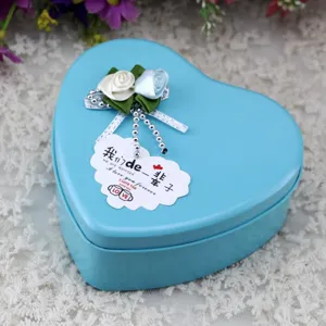 Dettaglio di una scatola regalo in metallo blu a forma di cuore con rose