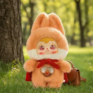 Adorable orange bunny plush art toy doll featuring a red cape and heart detail in a park
