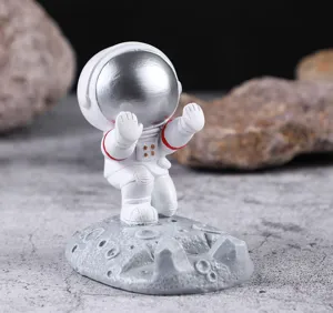 Vista detallada de un soporte creativo para teléfono de astronauta con base lunar de cráter