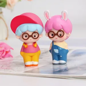 Detail shot of two cute cartoon blind box figures wearing glasses and colorful hats.
