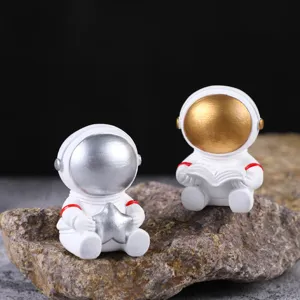 Figuras creativas de astronautas de resina sobre una roca para decoración del hogar.