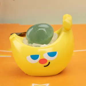 Vue détaillée d'un bol en céramique en forme de banane avec pierre d'énergie verte et cristaux