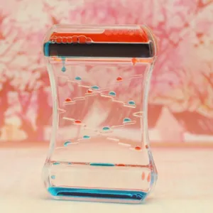 Vue détaillée d'un sablier à mouvement liquide bicolore avec gouttes d'huile rouges et bleues