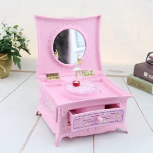 Detailansicht einer rosa Vintage-Schminktisch-Spieluhr mit Ballerina und offenem Schubfach