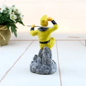 Dettaglio posteriore della statuina di Monkey King in abito giallo con bastone di metallo