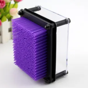 Vue rapprochée du jouet d'art 3D avec des épingles violettes et un cadre transparent.