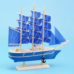 Detailed view of a Mediterranean style blue wooden sailboat model with blue fabric sails.