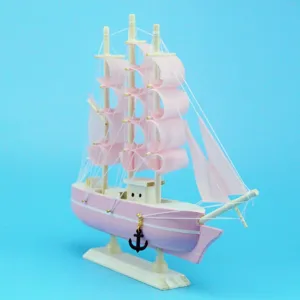 Exquisite detail view of a pink wooden sailing ship model in Mediterranean style