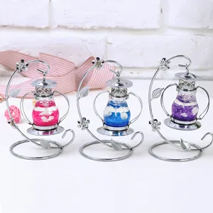 Detalle de tres velas de gelatina oceánica en soportes metálicos decorativos plata