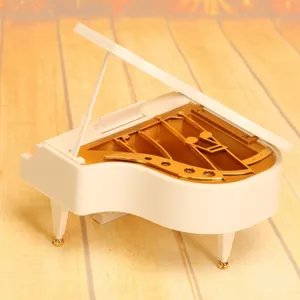 Detailansicht einer weiß-goldenen Spieluhr in Flügelform als dekoratives Geschenk