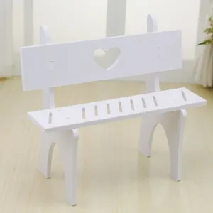 Detailed view of a miniature white decorative bench with a heart-shaped cutout for dolls