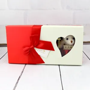 Détail de la fenêtre en forme de cœur sur la boîte cadeau de fleurs de savon avec un ours