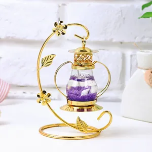 Vista detallada de un candelabro de hierro dorado con cera de gel púrpura y caracoles