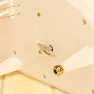 Detaillierte Nahaufnahme des mechanischen Aufziehschlüssels einer weißen Klavier-Spieluhr