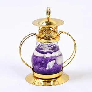 Detalle de vela de linterna dorada vintage con cera de gelatina púrpura y caracoles