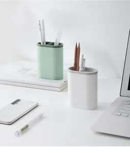 Minimalist double compartment plastic pen holder detail, clean desktop stationery storage scene.