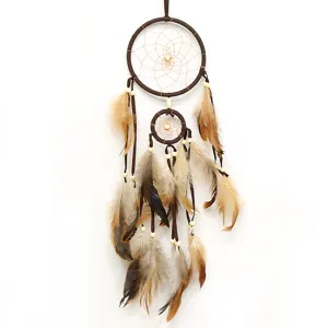 Gros plan de l'attrape-rêves marron style bohème avec plumes naturelles et perles en bois.