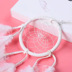 White feather dream catcher detail close up, minimalist home decor accessory and wall hang.