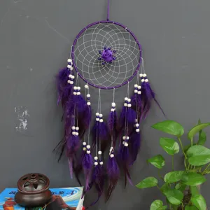 Atrapasueños morado hecho a mano para colgar en la pared con plumas y cuentas para decoración