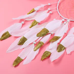 Handmade Indian style dream catcher with white feathers and gold glitter for home decor.