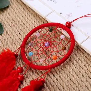 Roter Traumfänger Wandbehang mit bunten Perlen und Federn als schöne Boho Zimmer-Deko.