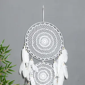 Handmade white crochet dream catcher with feathers, bohemian wall hanging for home decor.