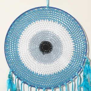 Handgefertigter Traumfänger mit blauem Auge und Federn für Boho-Wanddeko zu Hause.