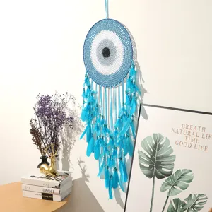 Blue evil eye dream catcher wall hanging detail, featuring feathers and beads in room decor.