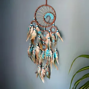 Bohemian sun and life tree dreamcatcher with teal and brown feathers hanging on wall