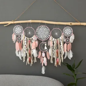 Attrape-rêves mural bohème fait main avec plumes et pompons pour décoration intérieure.