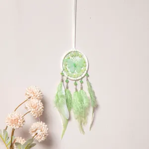 Green butterfly dream catcher detail view, feather and bead car hanging ornament decor.