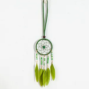 Close-up of a green ethnic dreamcatcher pendant necklace with feathers and beads
