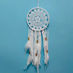 Detalle de atrapasueños blanco hecho a mano con encaje y plumas para decoración de pared