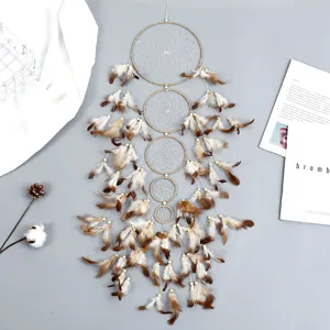 Gros plan sur l'attrape-rêves suspendu fait main avec plumes et perles en bois pour déco.