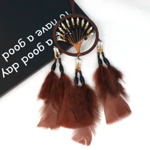 Detail shot of a brown tree of life dream catcher with feathers, ideal for car decor.