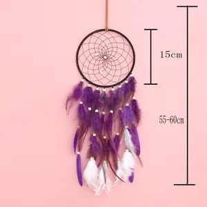 Detail view of handmade dream catcher with purple white feathers and wooden beads decoration.