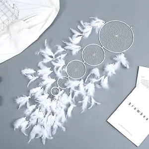Vue détaillée d'attrape-rêves en plumes blanches, décoration murale artisanale pour chambre.