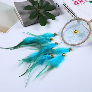 Detailed macro view of a handmade blue feather dreamcatcher with golden beads and rustic hemp frame
