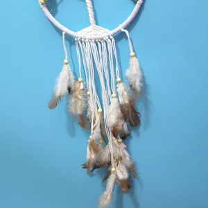 Close-up detail of boho white tree of life dreamcatcher with soft hanging feathers